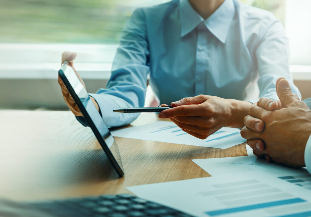 business consulting services. advisor and businessman working with digital tablet at desk in office. corporate strategy